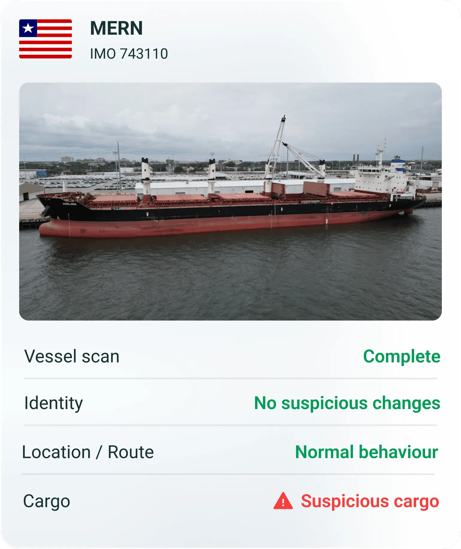 A cargo ship docked in a harbor with details about its vessel name and location displayed below.