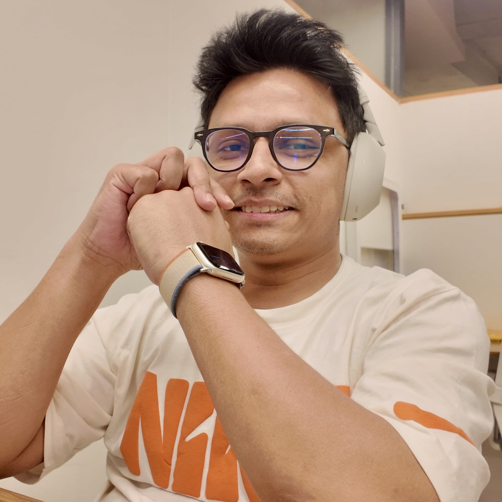 A person in a winter coat and furry hat walking along a snow-covered path through a forest of frosted trees.