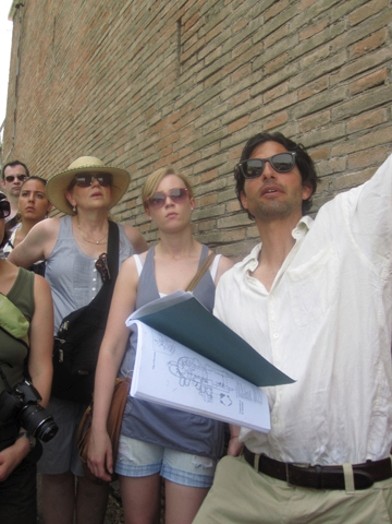 A photo of a group of people visiting old buildings in Rome.