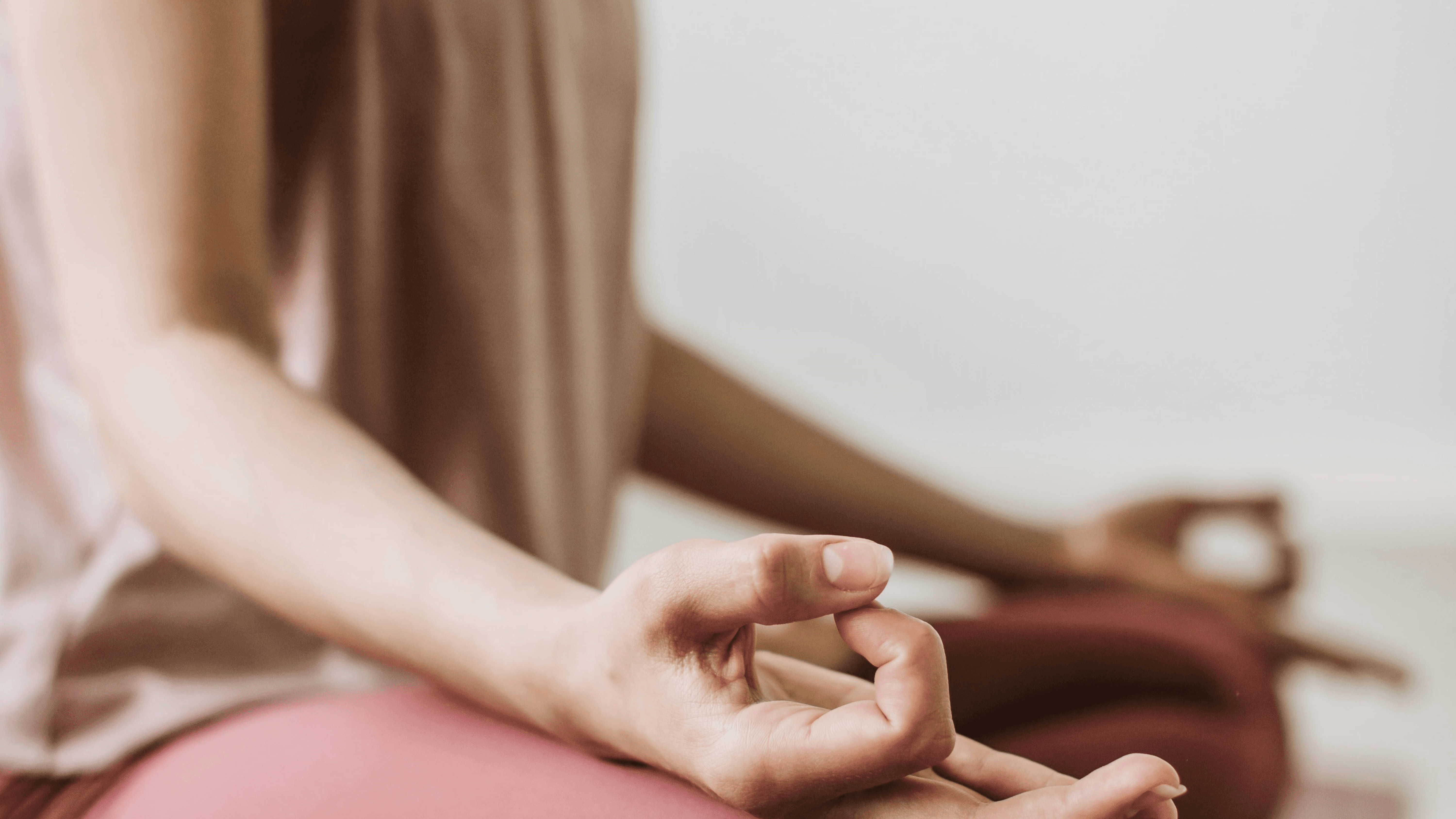 A person with curly hair sits at a desk, working on a laptop in a cozy, well-lit environment.