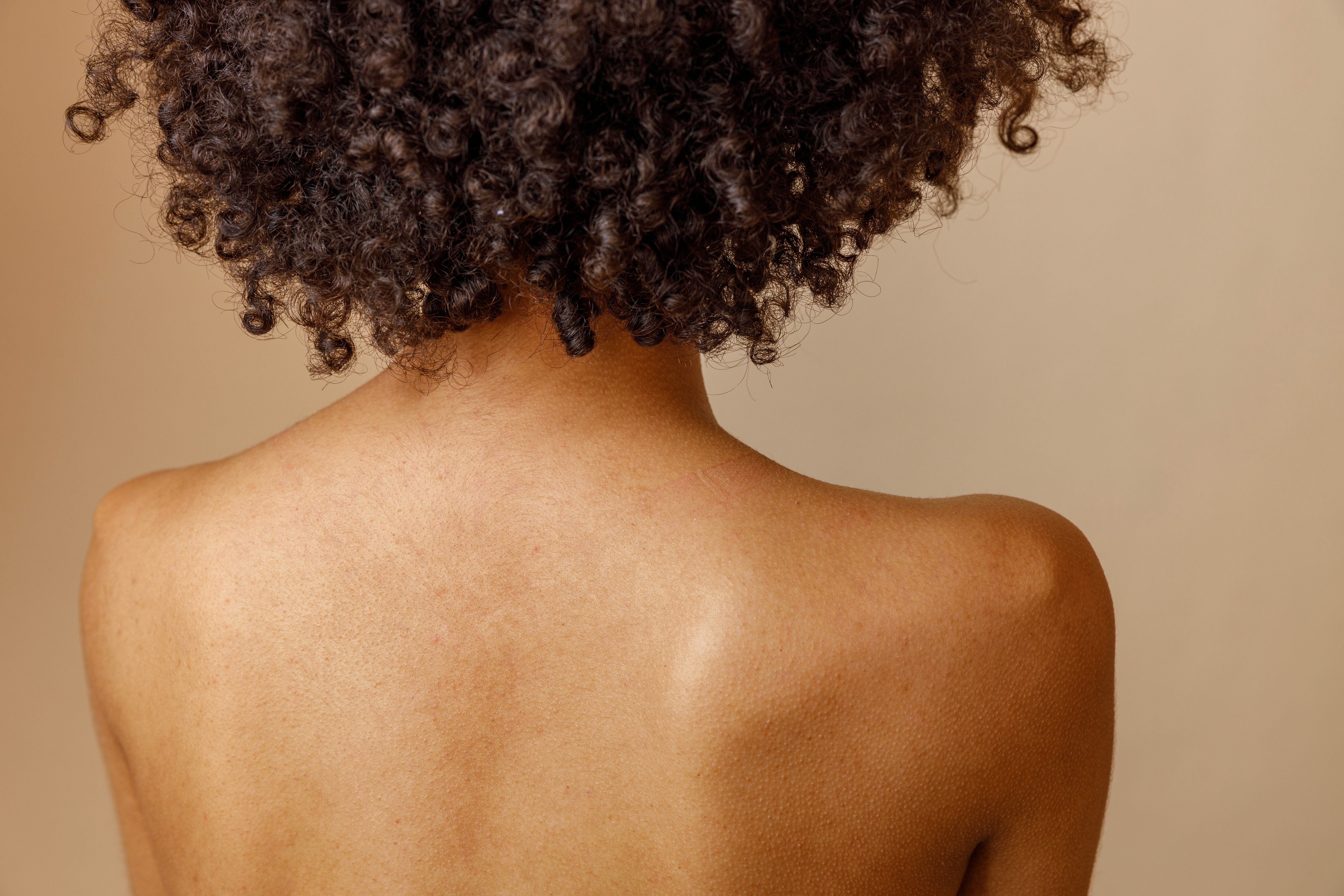 Espalda femenina que simboliza el aprendizaje y el cuidado consciente en la formación médico-estética de Asirox Academy.