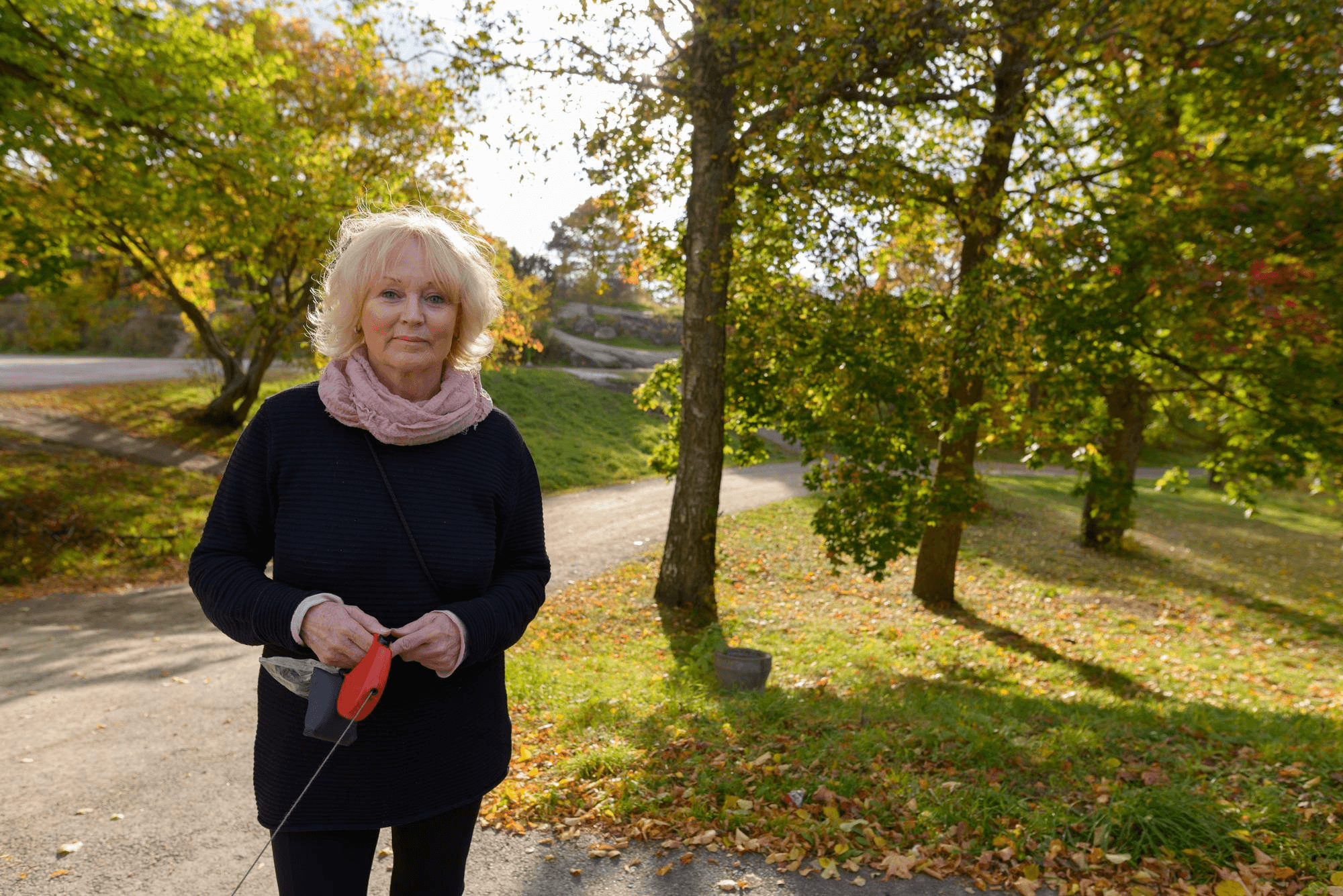 Woman standing in park walking a dog
