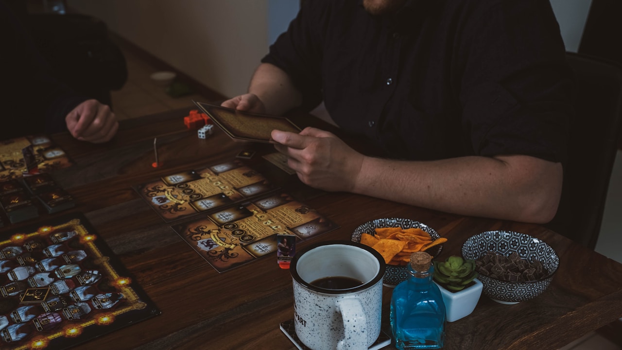 Friends playing board games together with snacks on the table | Photo by 2H Media on Unsplash