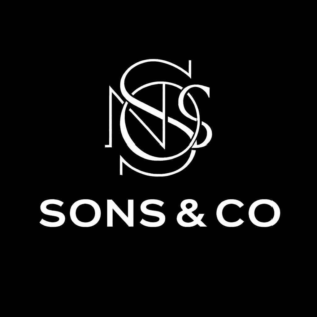 man sitting facing silver MacBook inside room