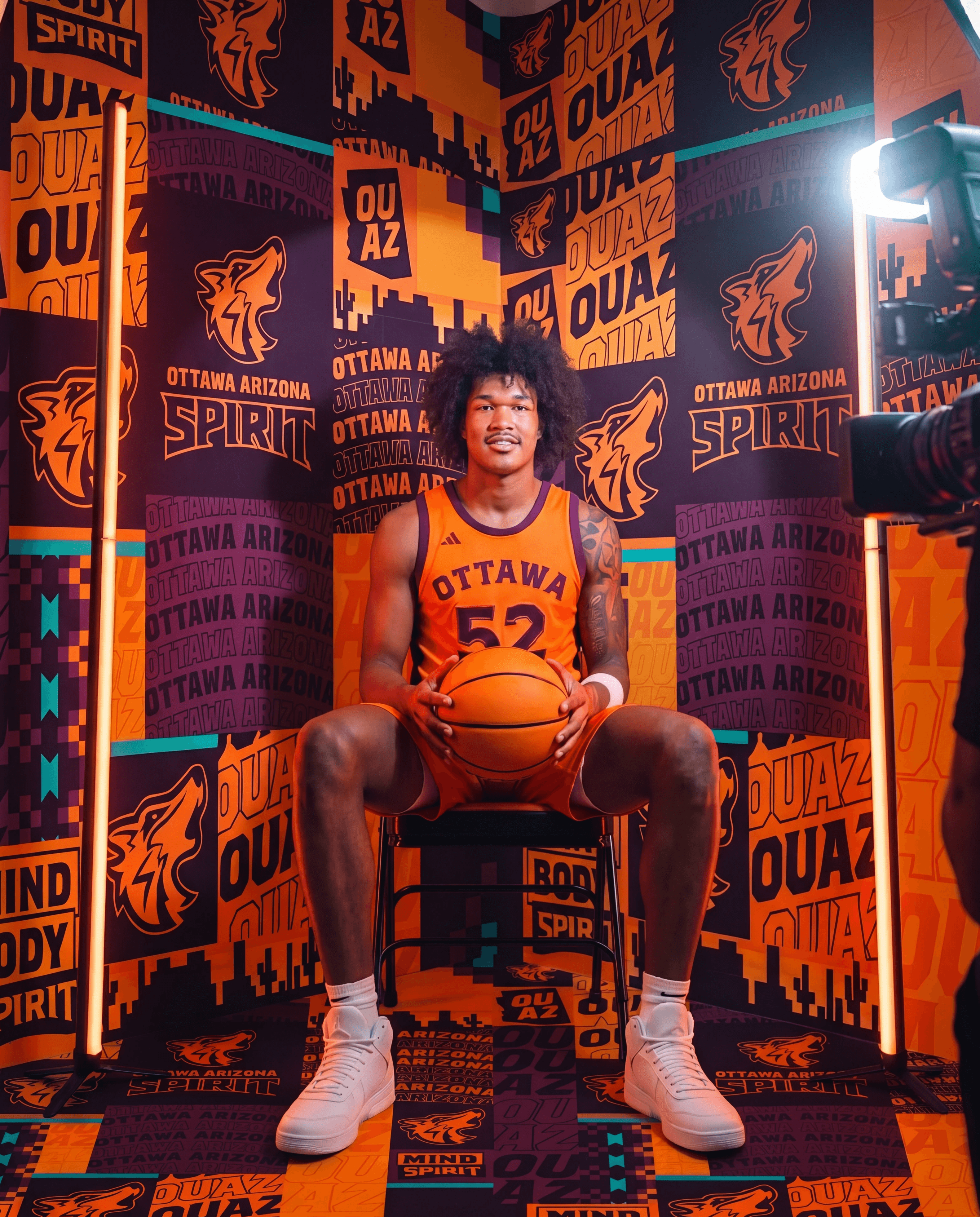 Player standing in front of OUAZ Media Day backdrop design