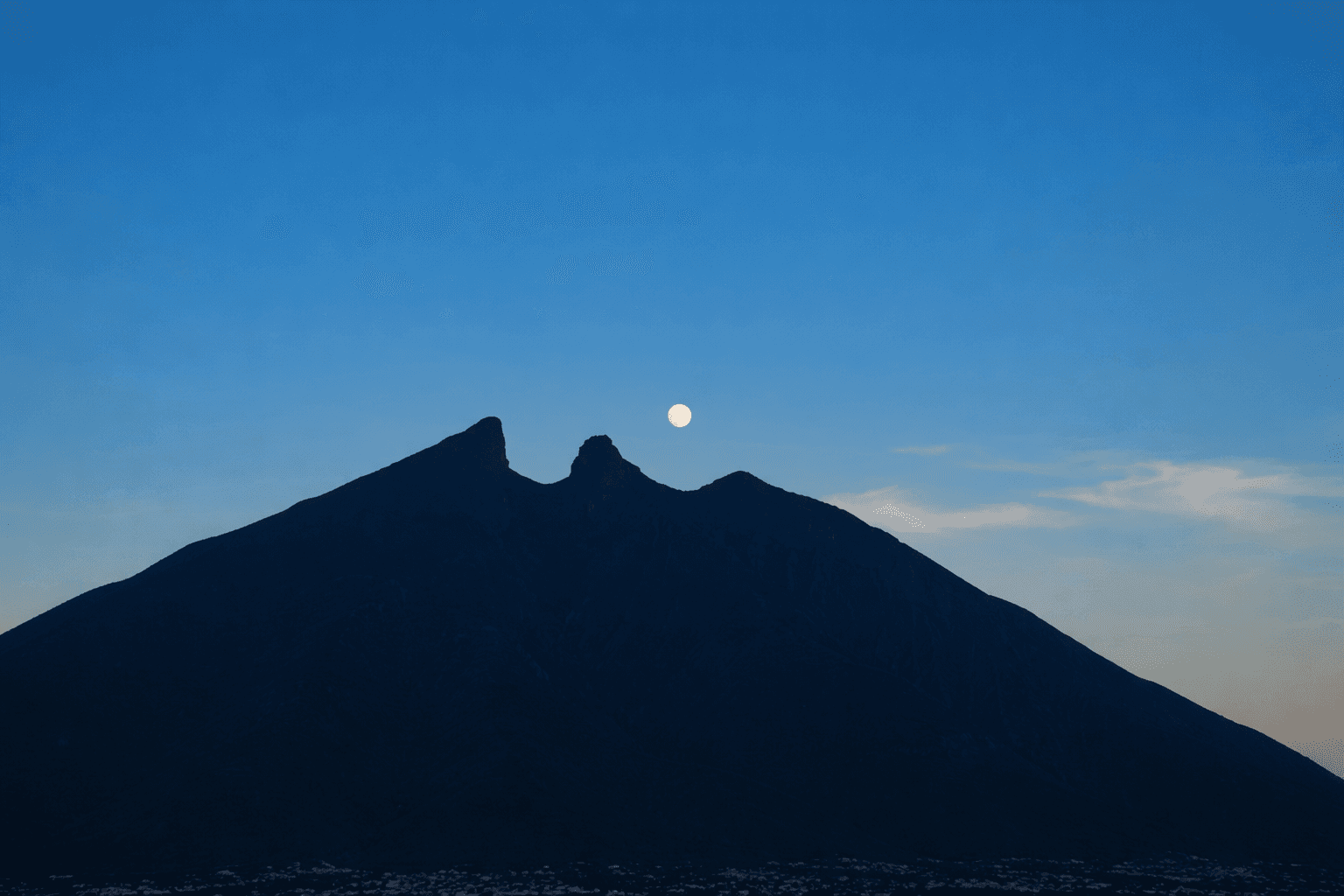 silhouette of mountain under blue sky during night time