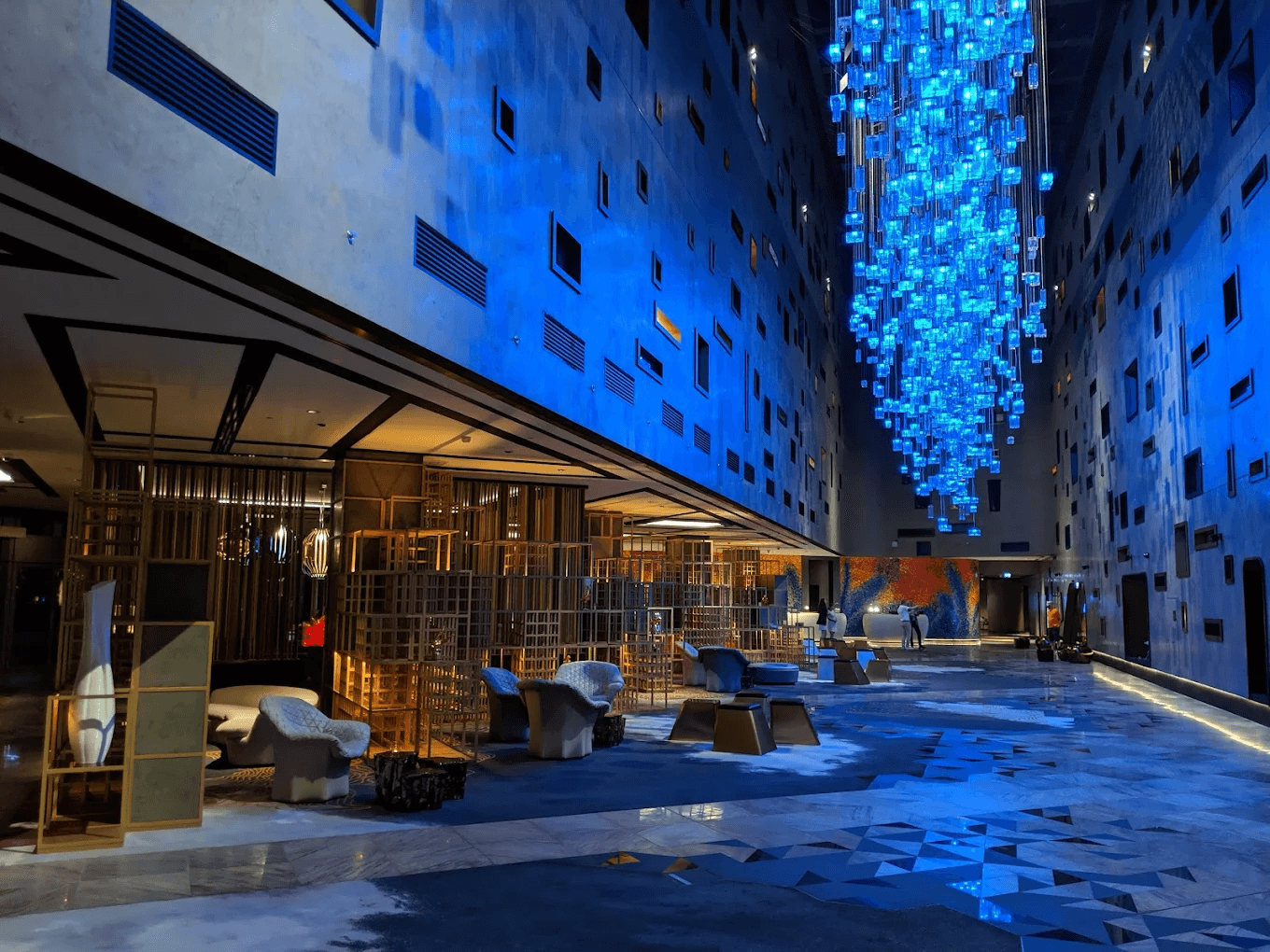 Interior view of W Dubai – The Palm, a modern pet-friendly hotel featuring artistic blue lighting and contemporary lounge spaces.