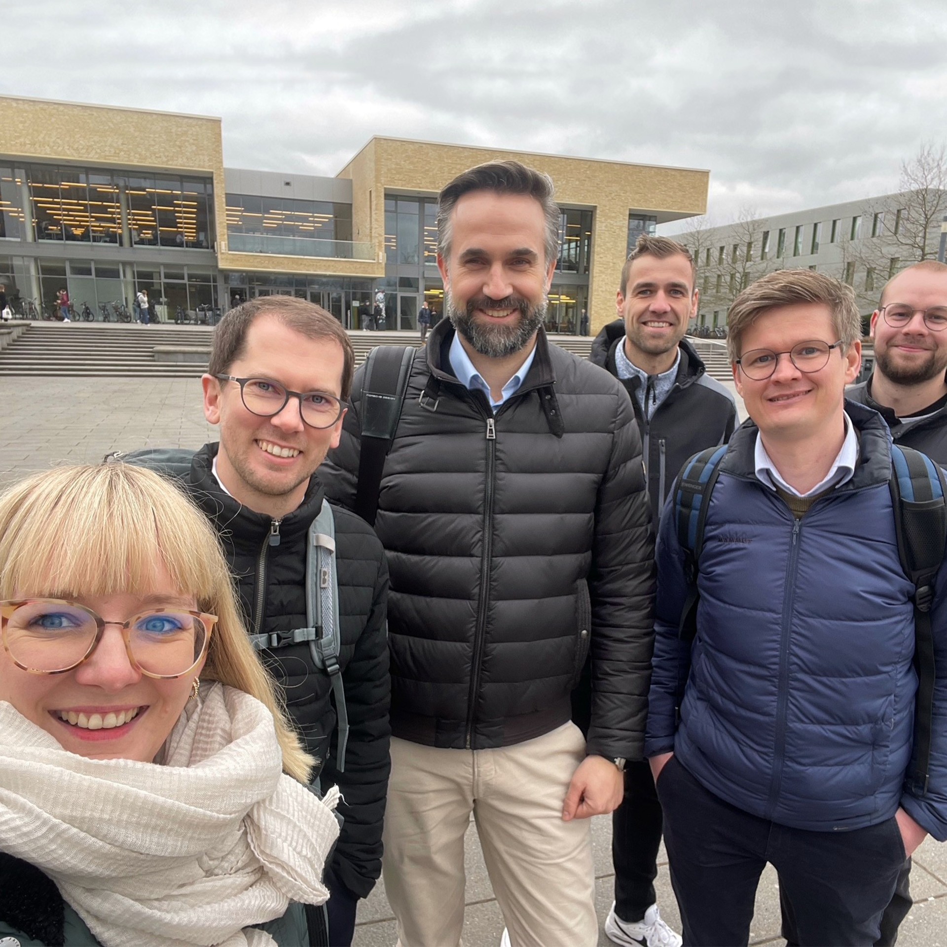 Gruppe von Personen vor Universitätsgebäude. Treffen, Teamwork, Campus