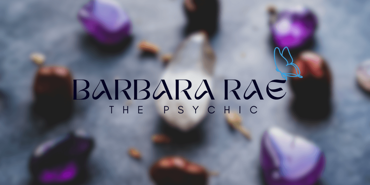 Smiling older woman with gray hair stands before pink and white flowers, representing psychic Barbara Rae and her intuitive guidance.
