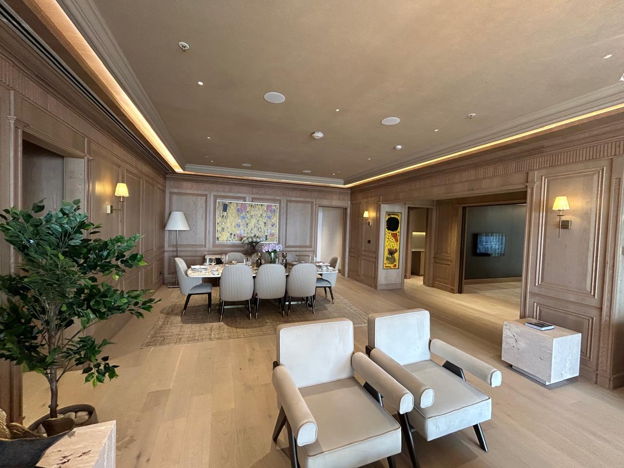 Vintage-modern living room with tufted sofas, false ceiling, and layered warm lighting.