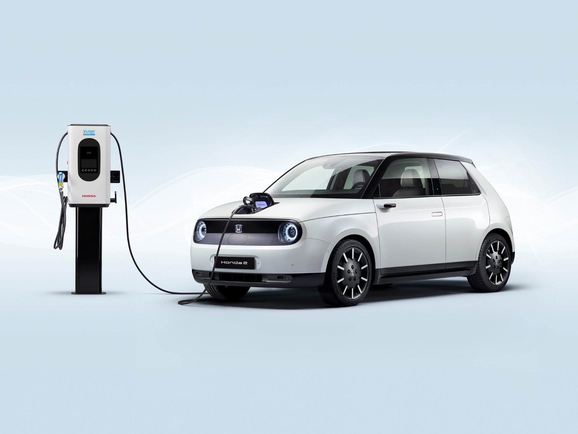 Honda e electric car connected to a charging station, illustrating the use of charging infrastructure to support electric mobility and sustainable transportation solutions in Switzerland