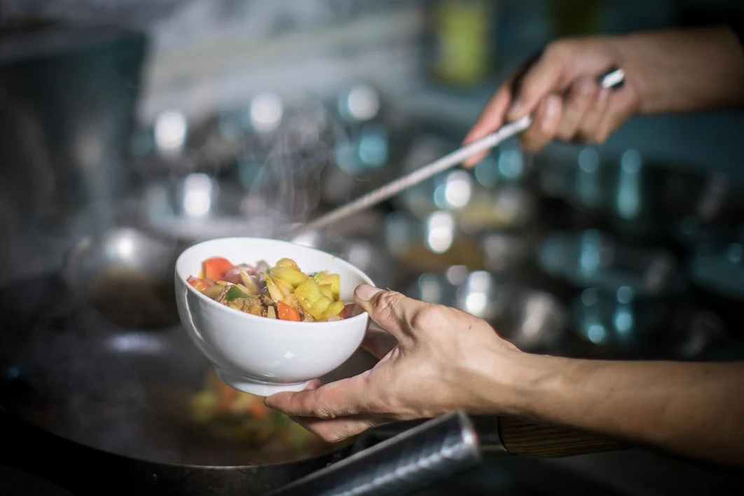 Chef preparing a fresh dish in a resort kitchen.