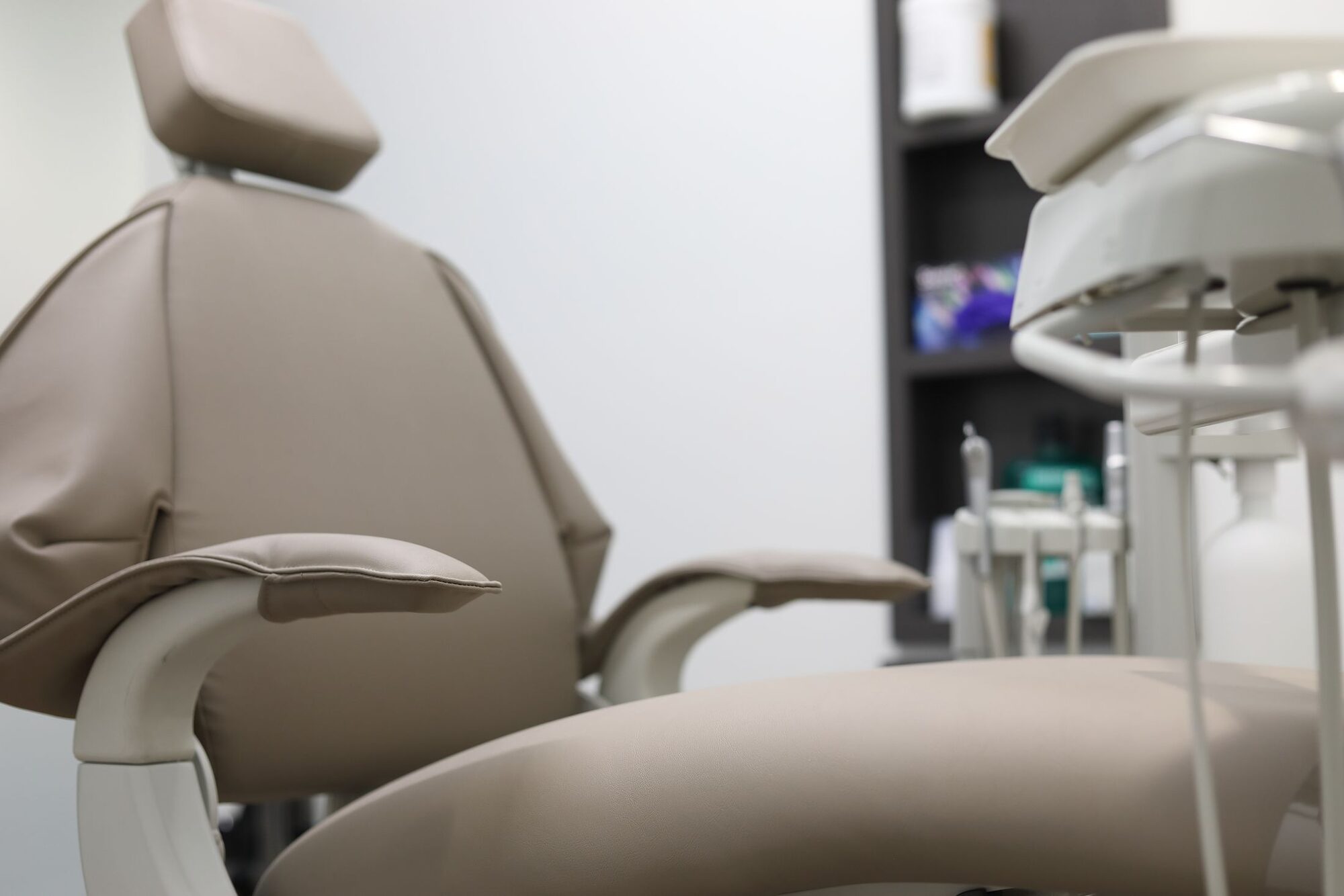 A sand-colored dental chair in a calm, softly lit treatment room