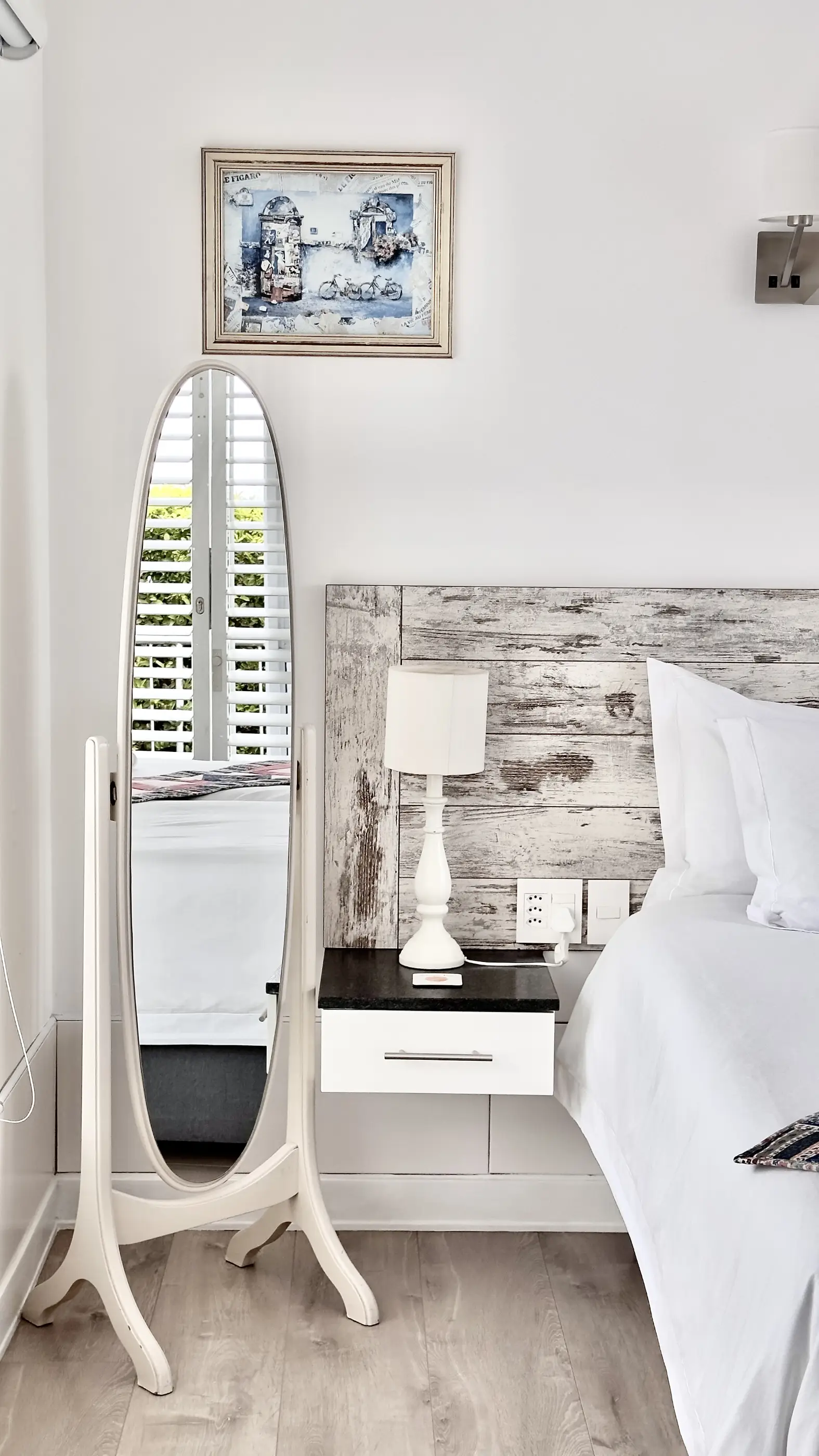 Closeup view of the bed and bedside table with lamp in the 1 For All room at Somerset View Guest House.