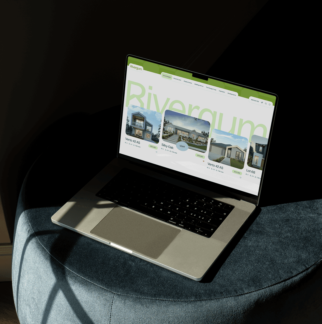 Rivergum Homes homepage, shown on a laptop on a cushion.