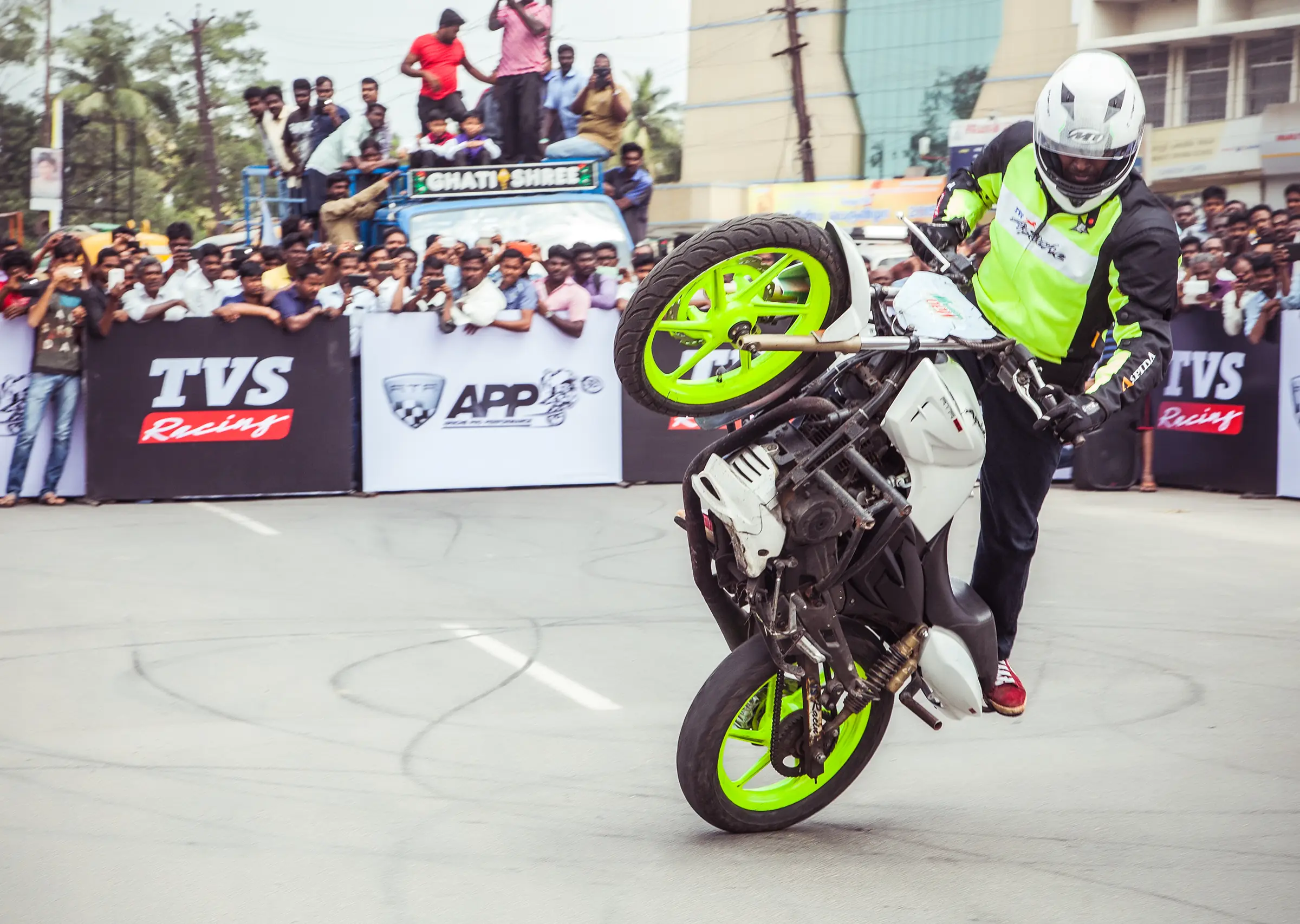 A man performing a wheelie on a motorcycle outdoors during lifestyle photo shoot capture by tapecassette