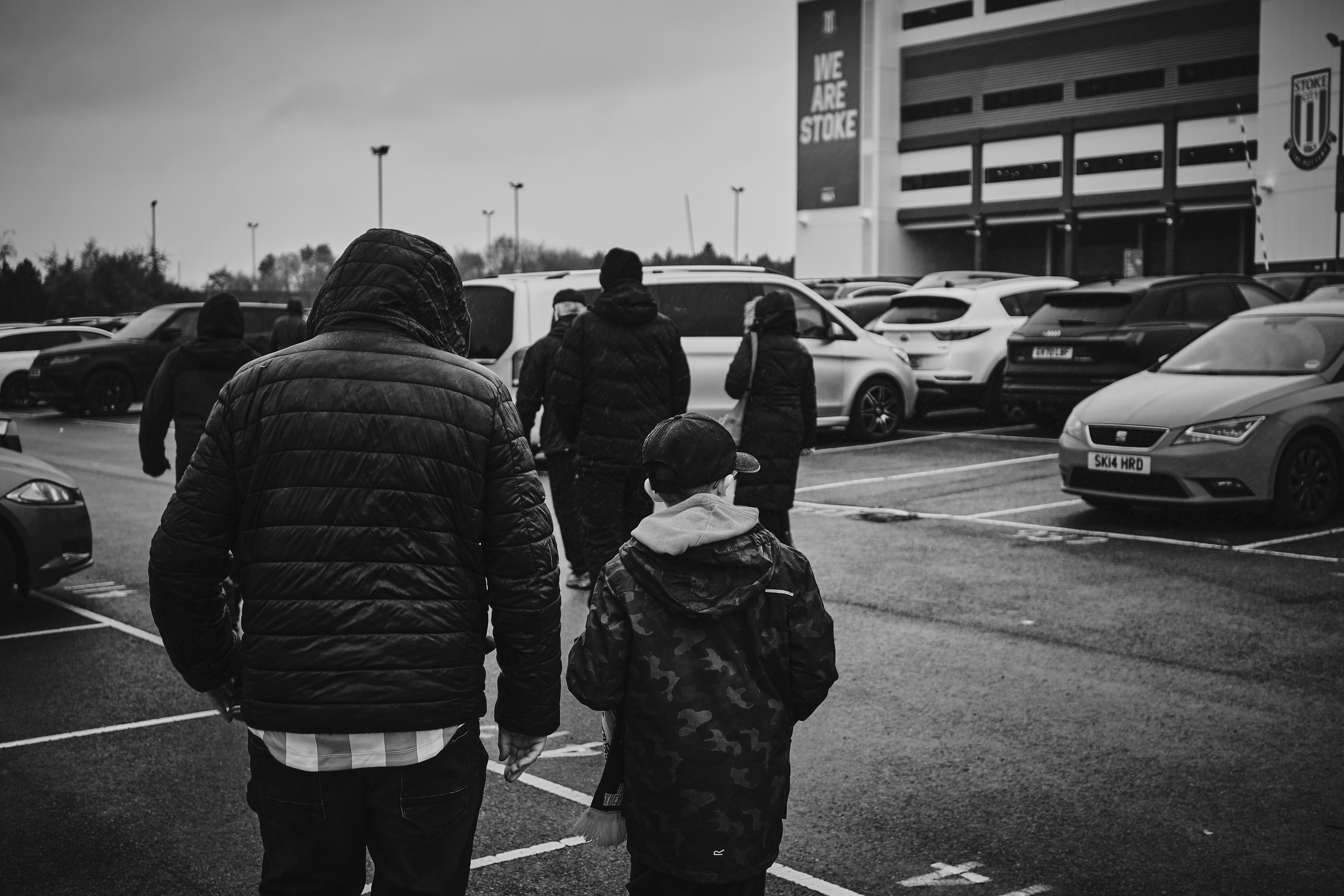 a group of people standing in a parking lot