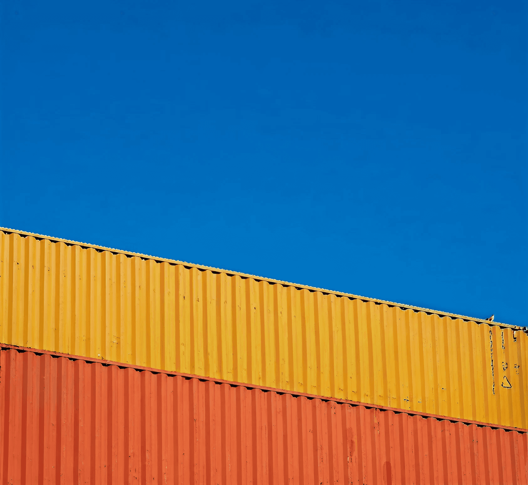 a blue sky with a yellow and orange container on top of it