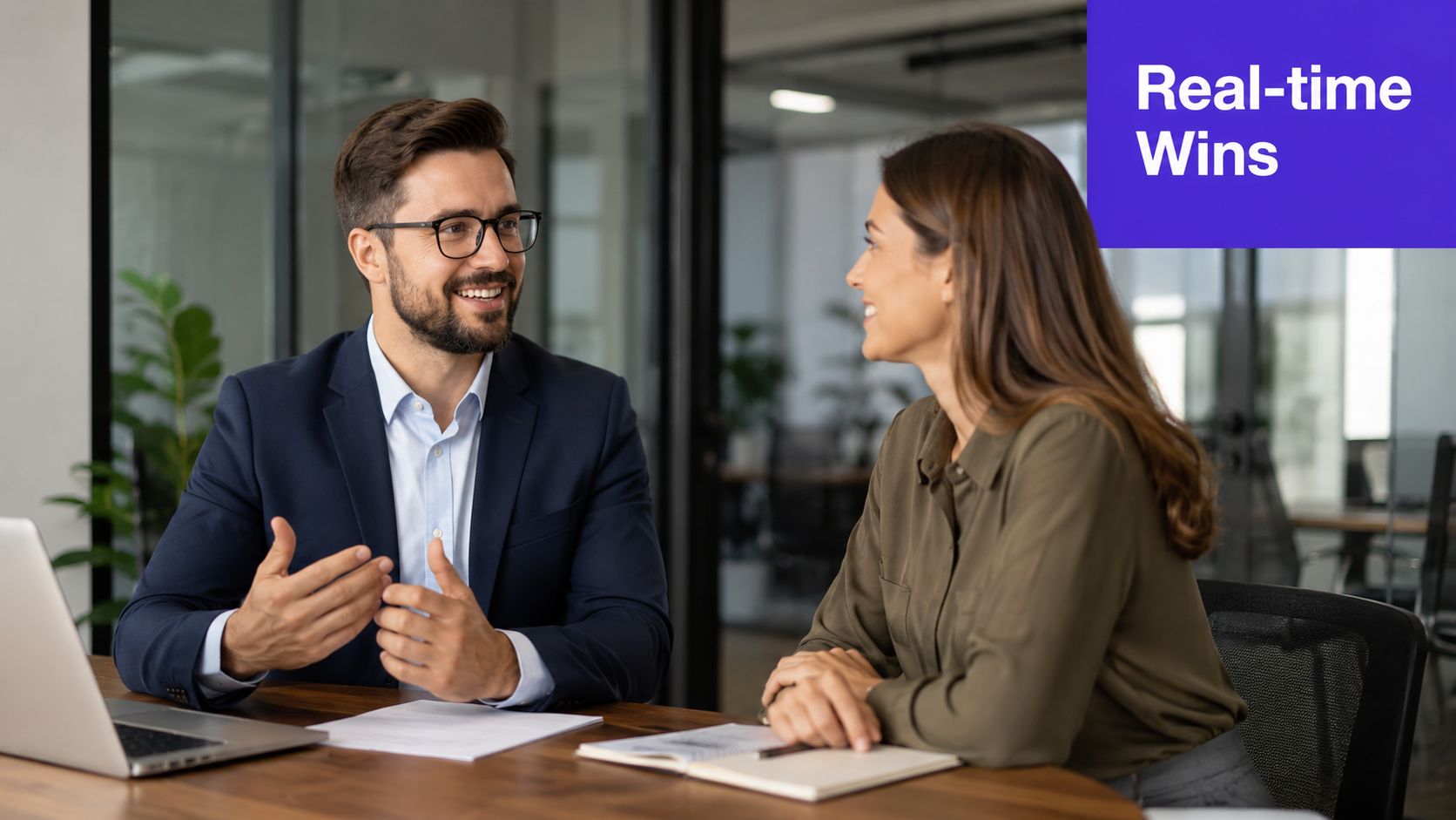 A professional man and woman having a productive conversation in a modern, bright corporate office workspace.