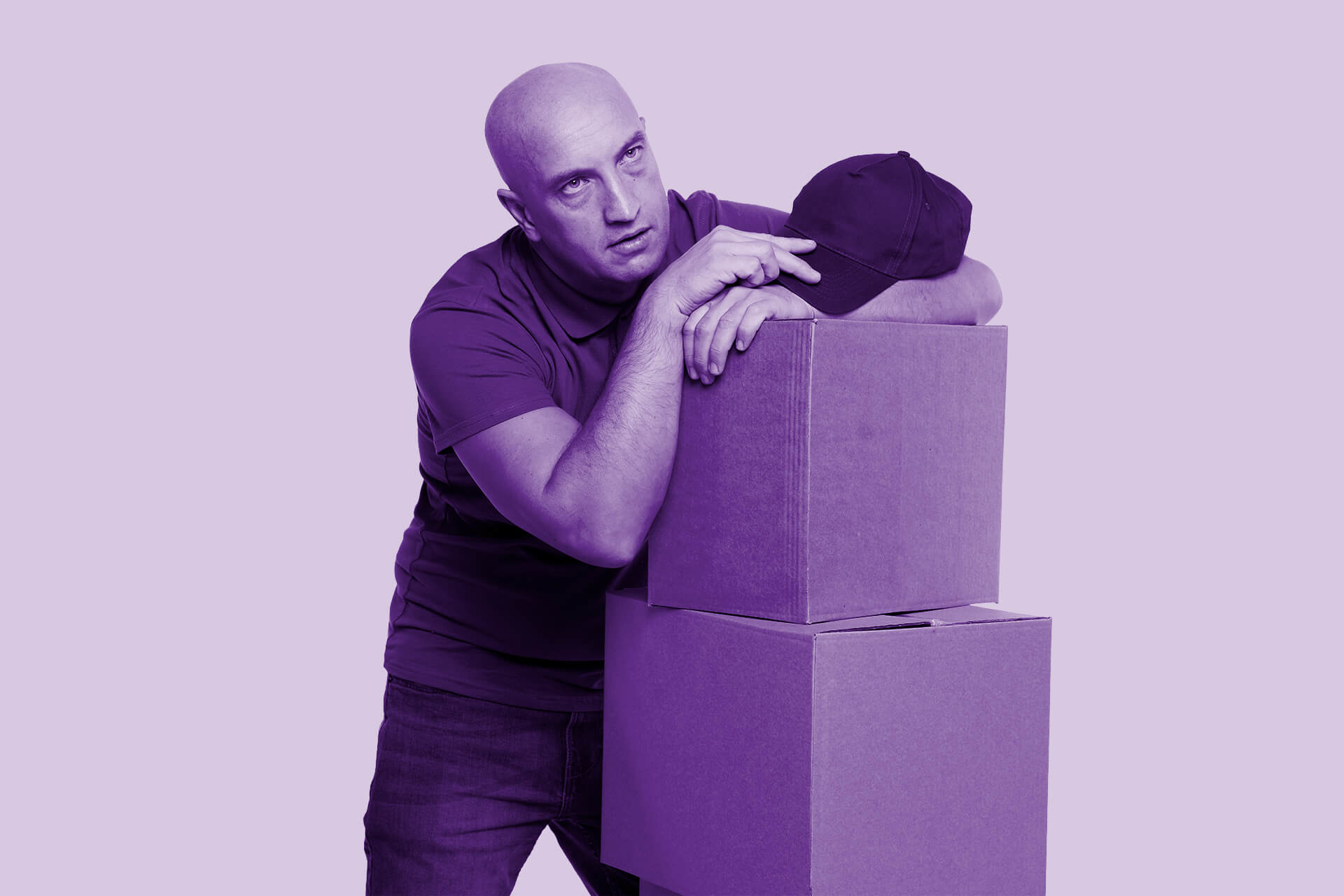 Man leaning on boxes of event materials, looking tired — illustrating the challenge of transporting event gear to exhibitions.