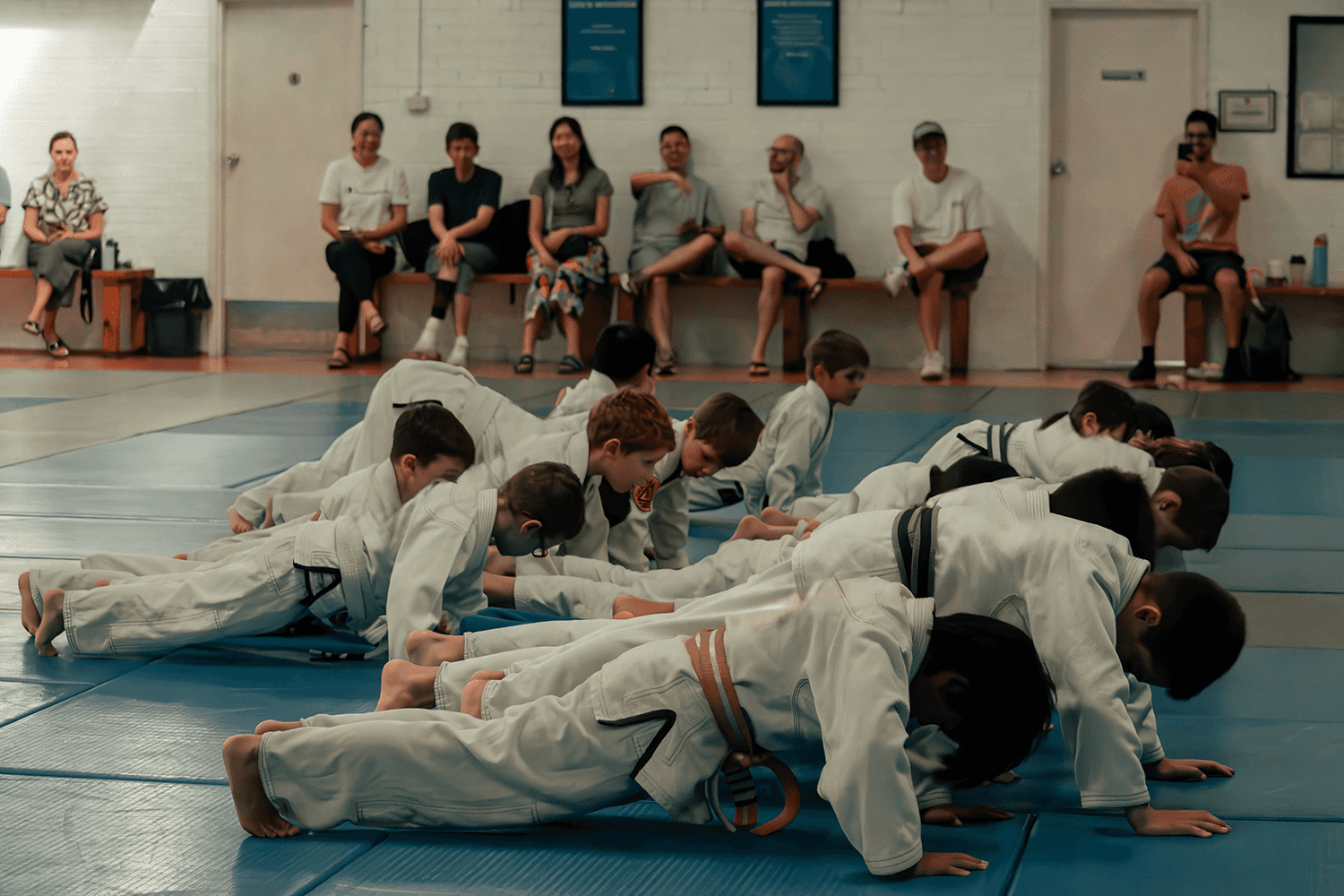 Children training in Jiu Jitsu, one in blue gi facing a classmate in white gi