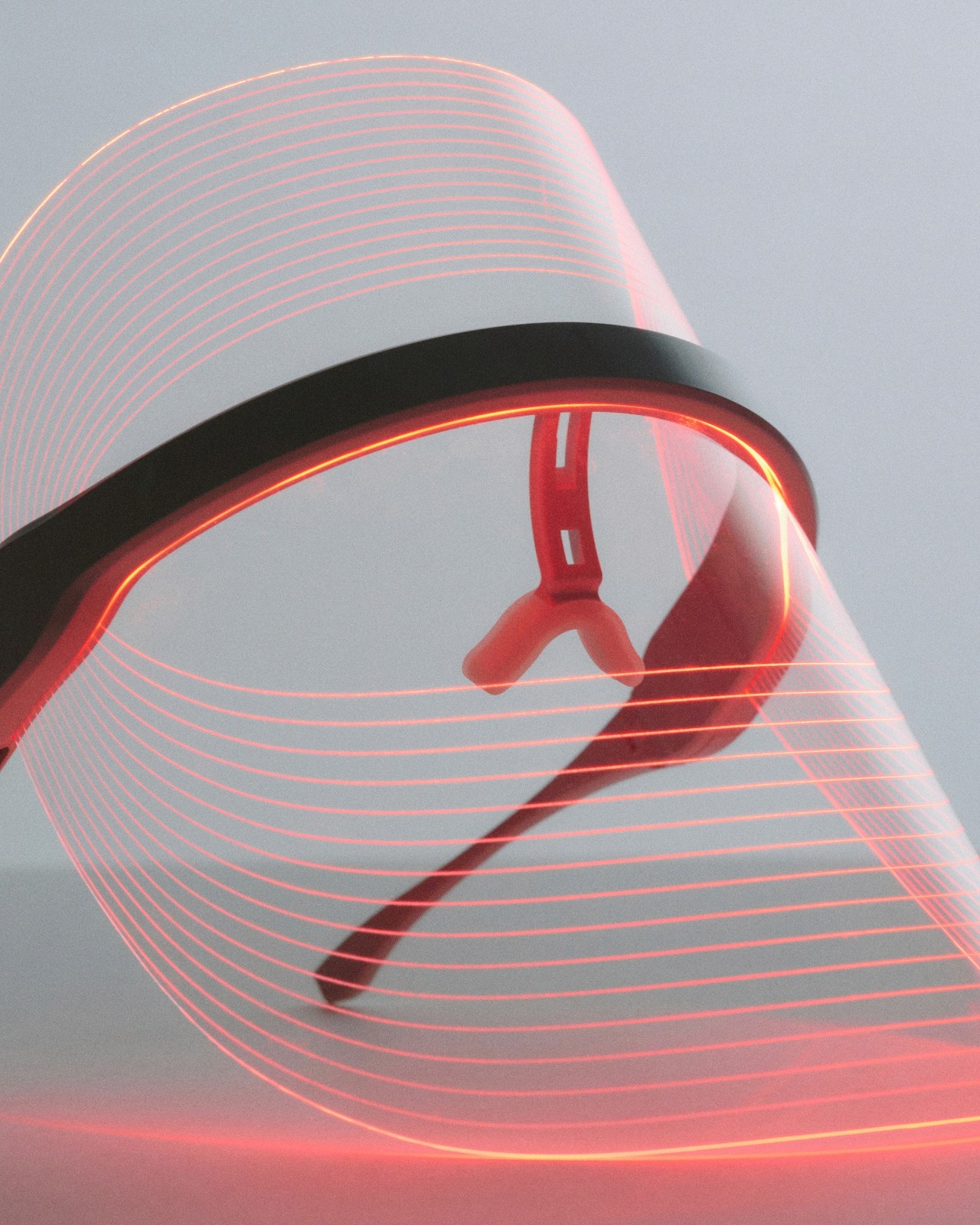Glasses surrounded by flowing light lines on a neutral background.