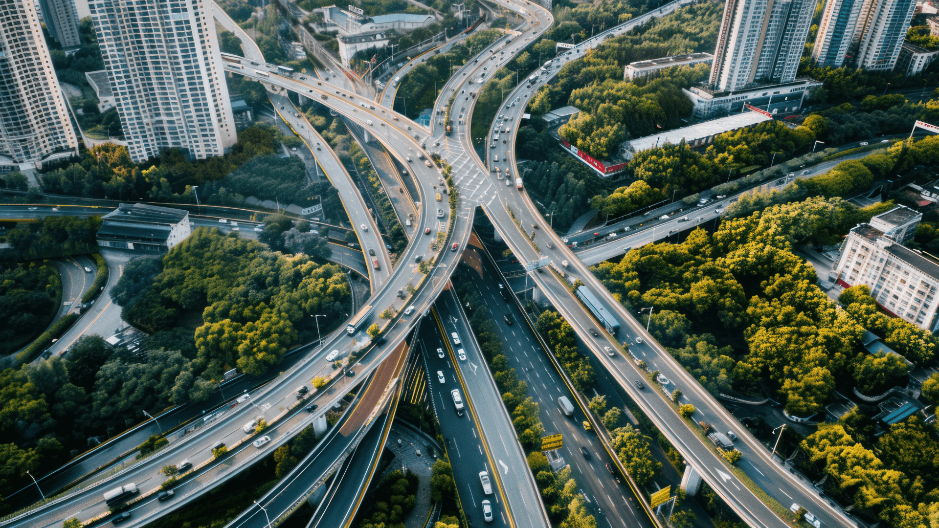 Aerial view of urban road infrastructure surrounded by green space, showing how sustainable planning and facilities management support net zero cities.