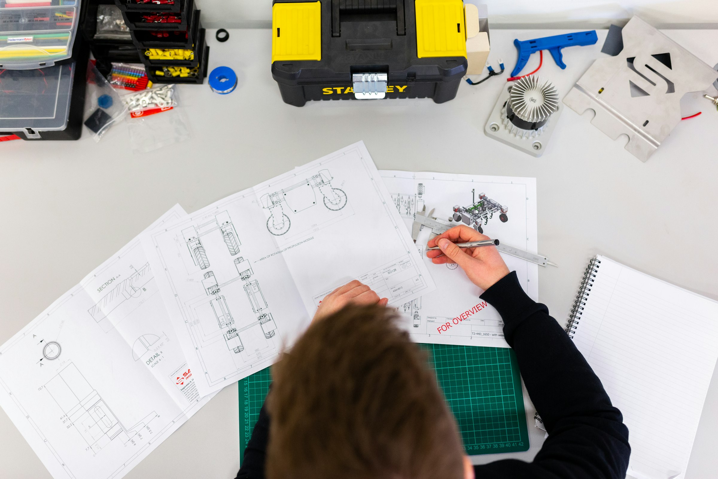Engineer measuring a technical drawing with a caliper
