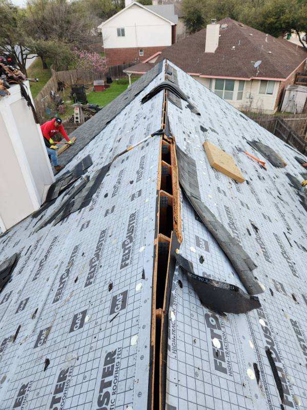 Barnes N' Roofs crew member removing old roofing materials and installing a new roof with professional craftsmanship on a residential property.