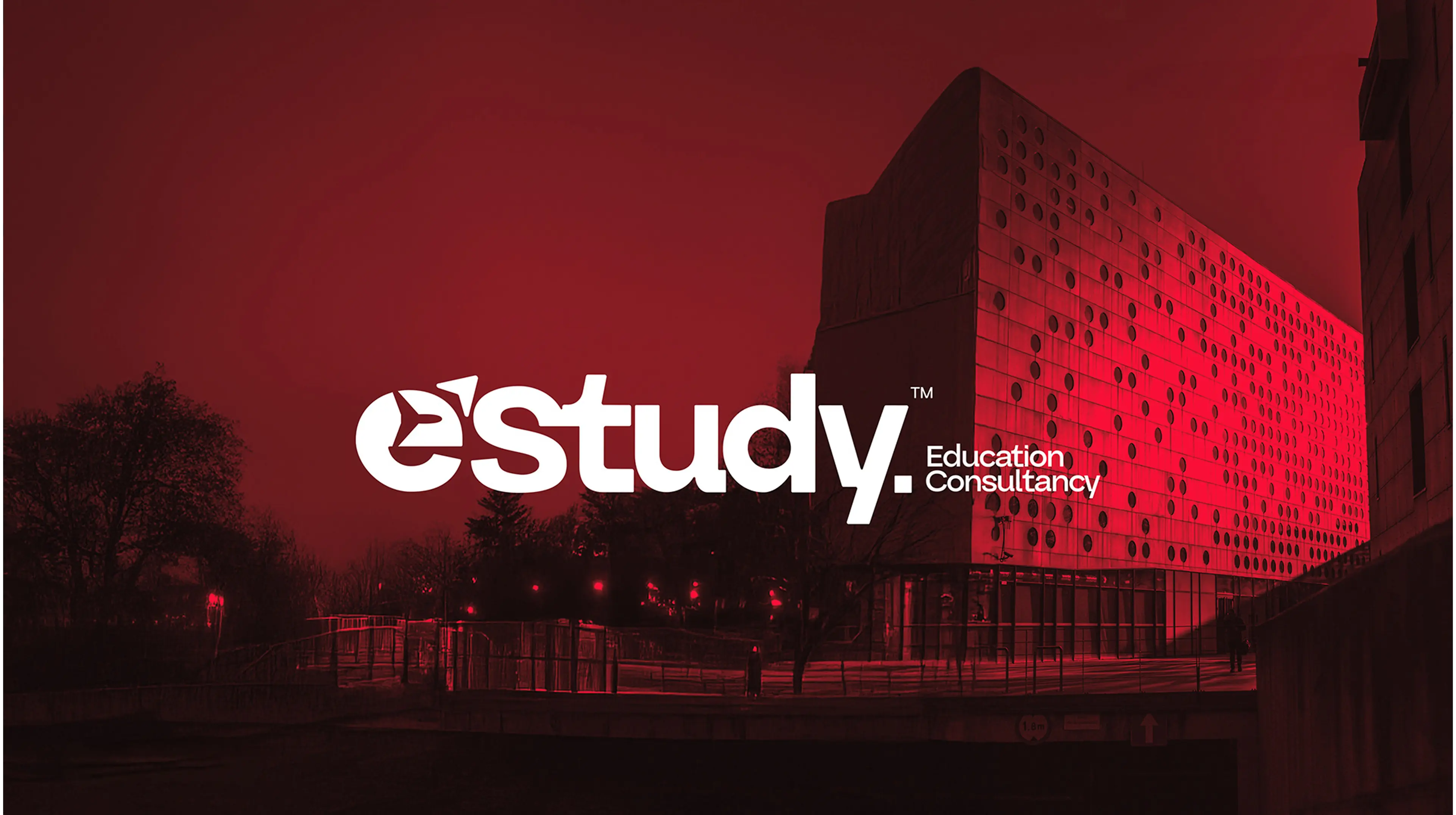 Estudy Education Consultancy logo displayed on a modern university building with dramatic red lighting