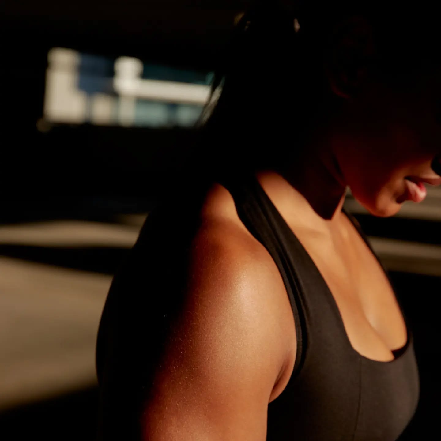 Black cosmetic product bottle against a dark background