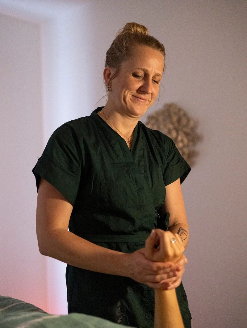 Amy masse la main d’une cliente pendant une séance