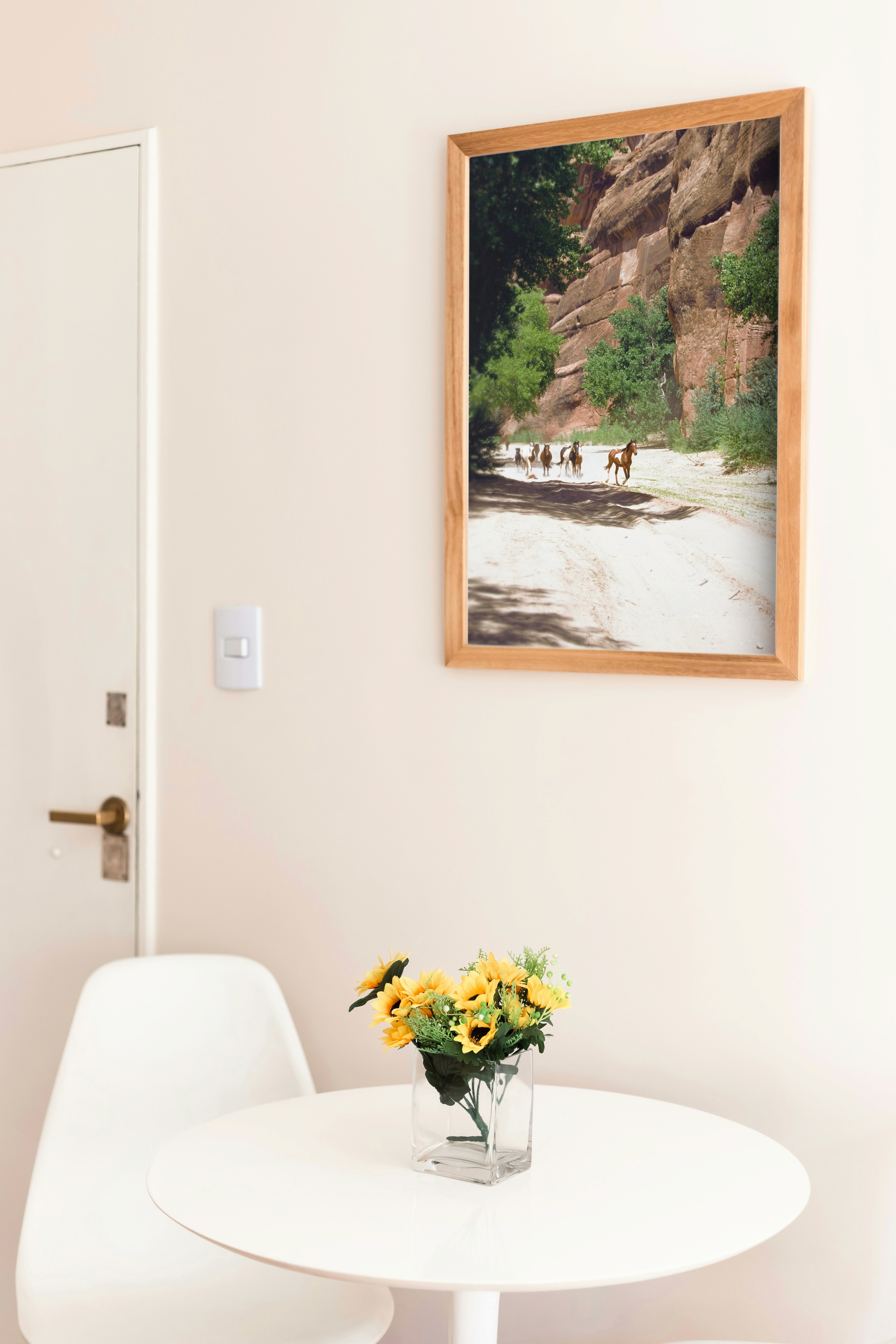 Modern indoor space with large glass doors, lush greenery, and a cozy seating area visible beyond.