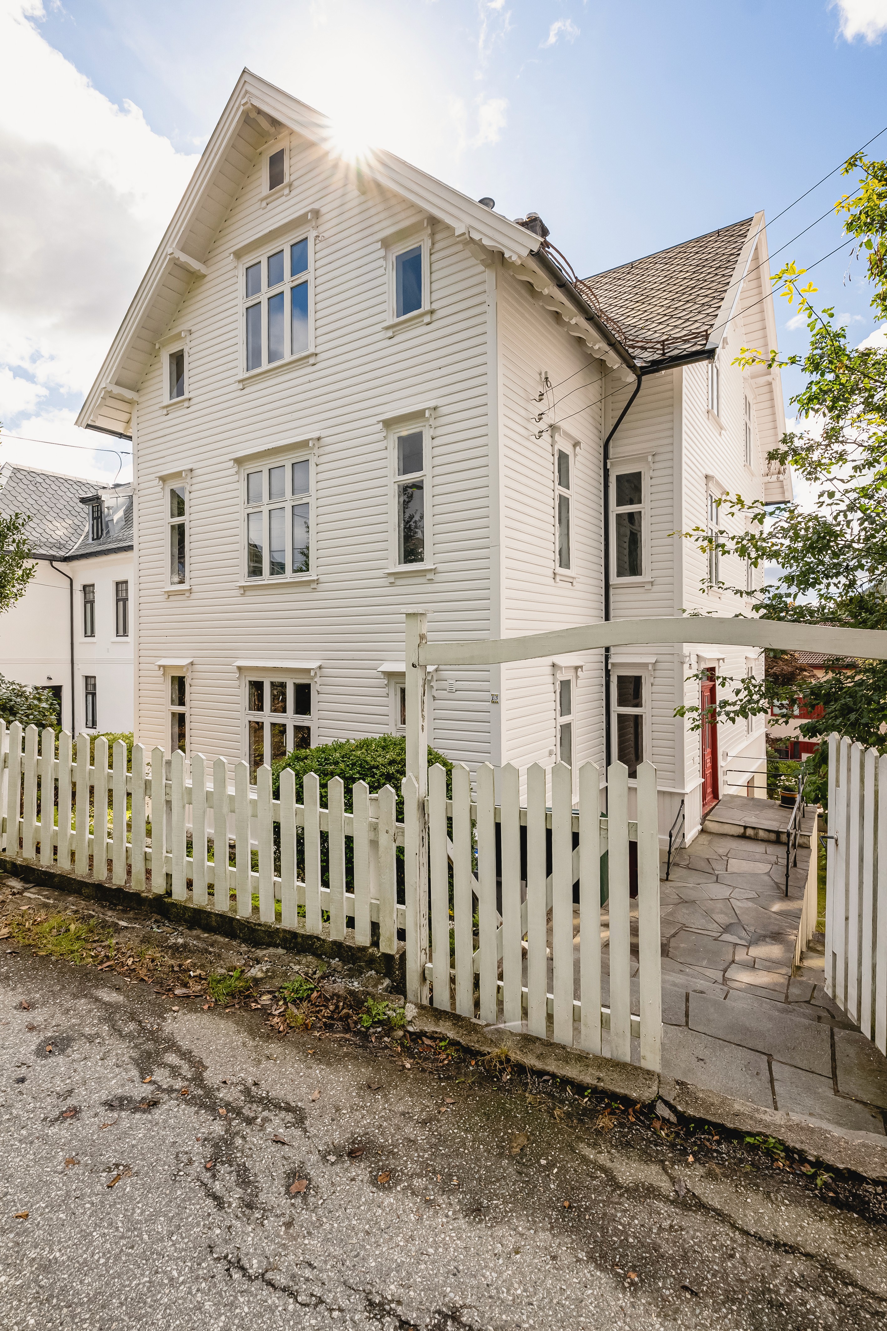 A white house with a gray roof and a brown door