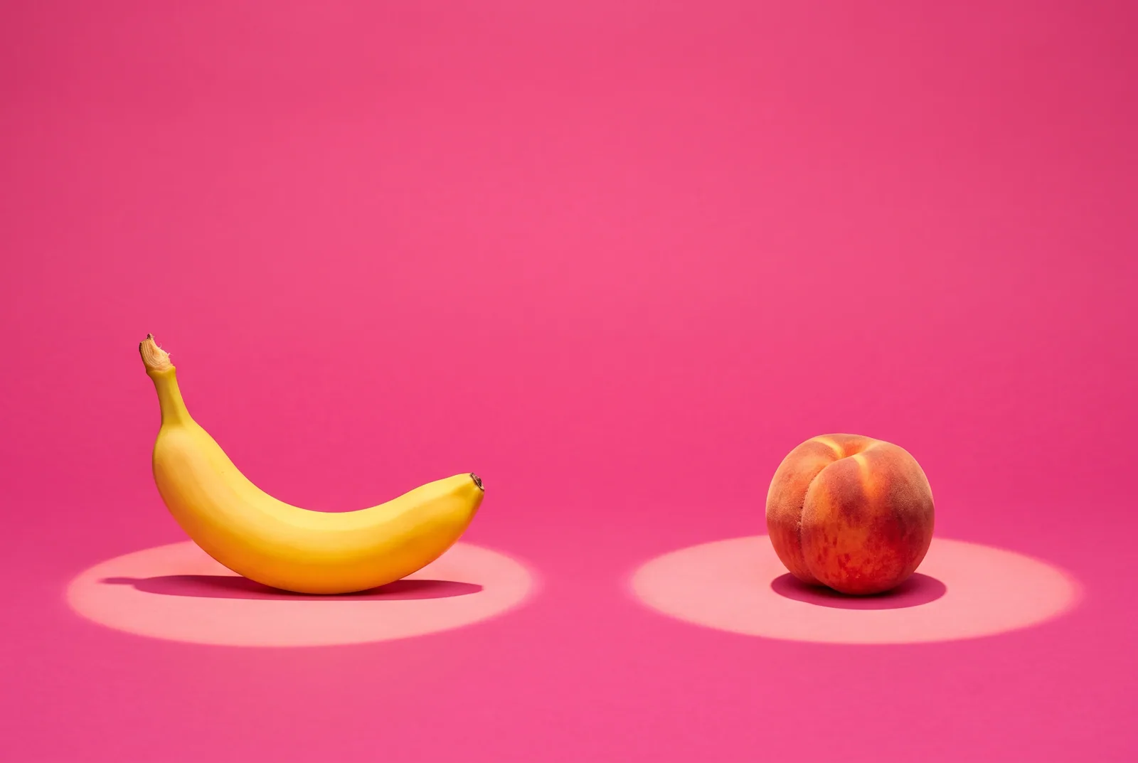 A banana and a peach in two separate spotlight circles facing each other, QUITTR vs Ever Accountable head to head