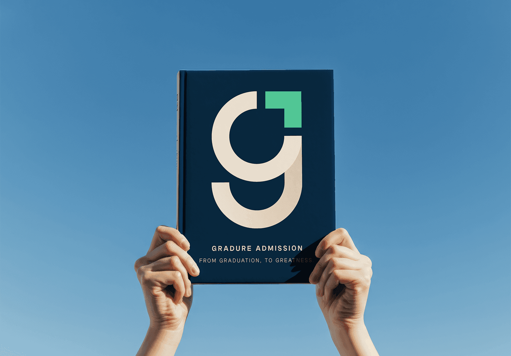 Hands holding up a Gradure Admission booklet with a bold modern ‘G’ logo on a navy blue cover against a clear blue sky.