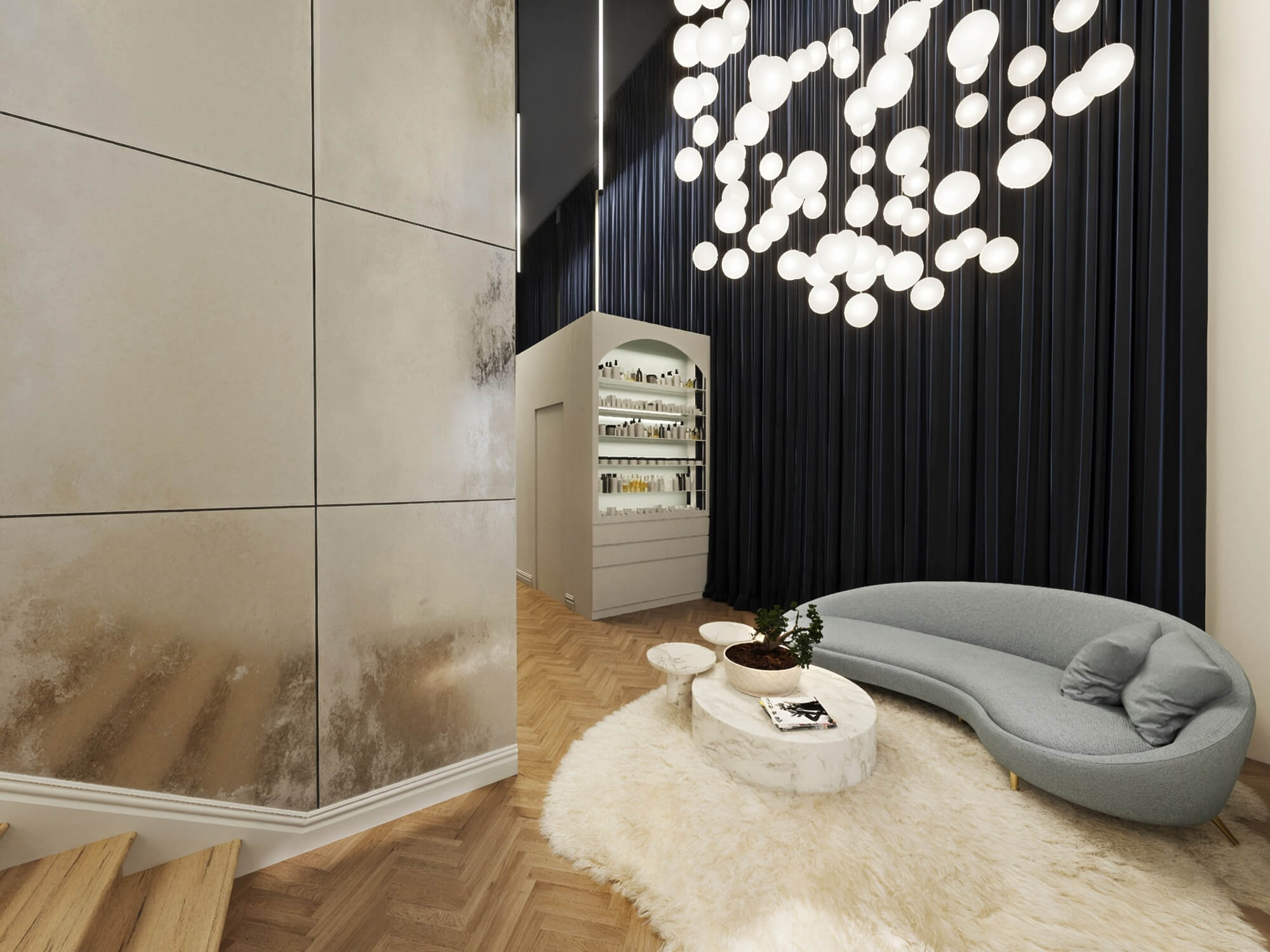 Contemporary luxury salon reception area with curved blue velvet couch, marble coffee table, custom pendant chandelier, and herringbone wood floor.