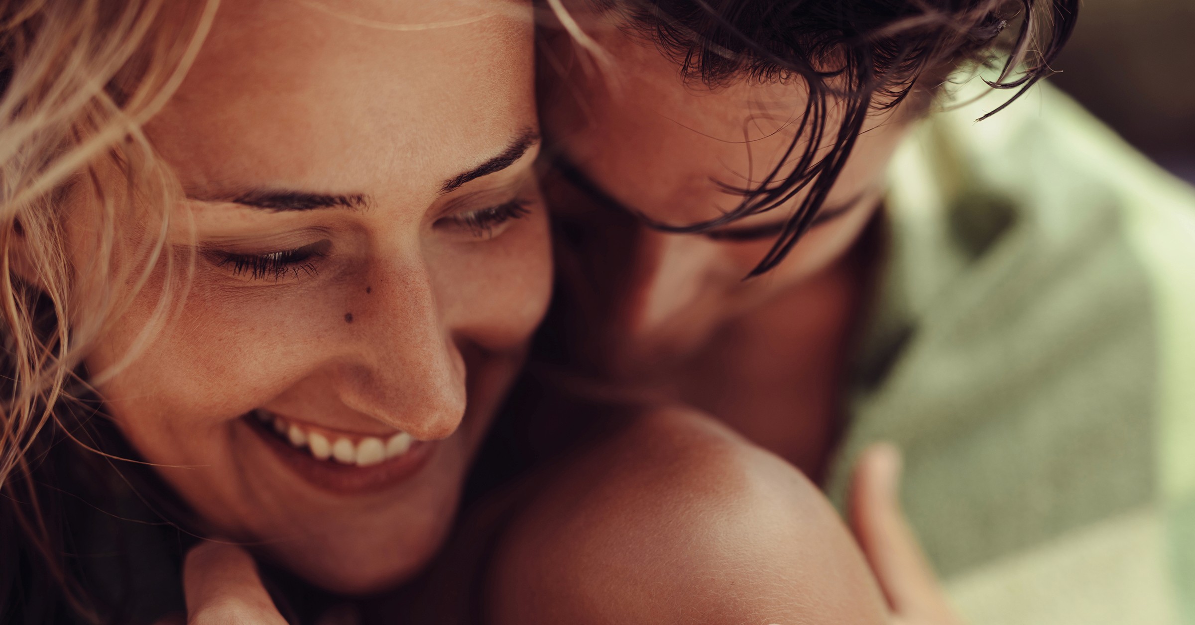 A loving couple - where the woman looks back at the man while he kisses her shoulder