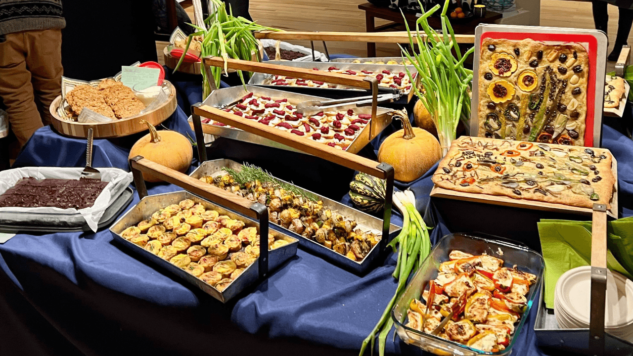 Farm-to-table dishes arranged on a table, including focaccia, roasted vegetables, squash, and seasonal produce from Rooted Northwest farms.