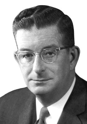 Physicist and Nobel laureate Donald A. Glaser is shown in this black-and-white portrait, wearing glasses, a suit, and a tie, with a confident expression. Renowned for inventing the bubble chamber, Glaser's work greatly advanced experimental particle physics by enabling the visualization of subatomic particles.