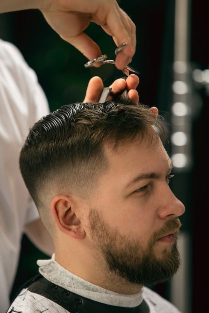 Barber cutting hair with scissors and comb