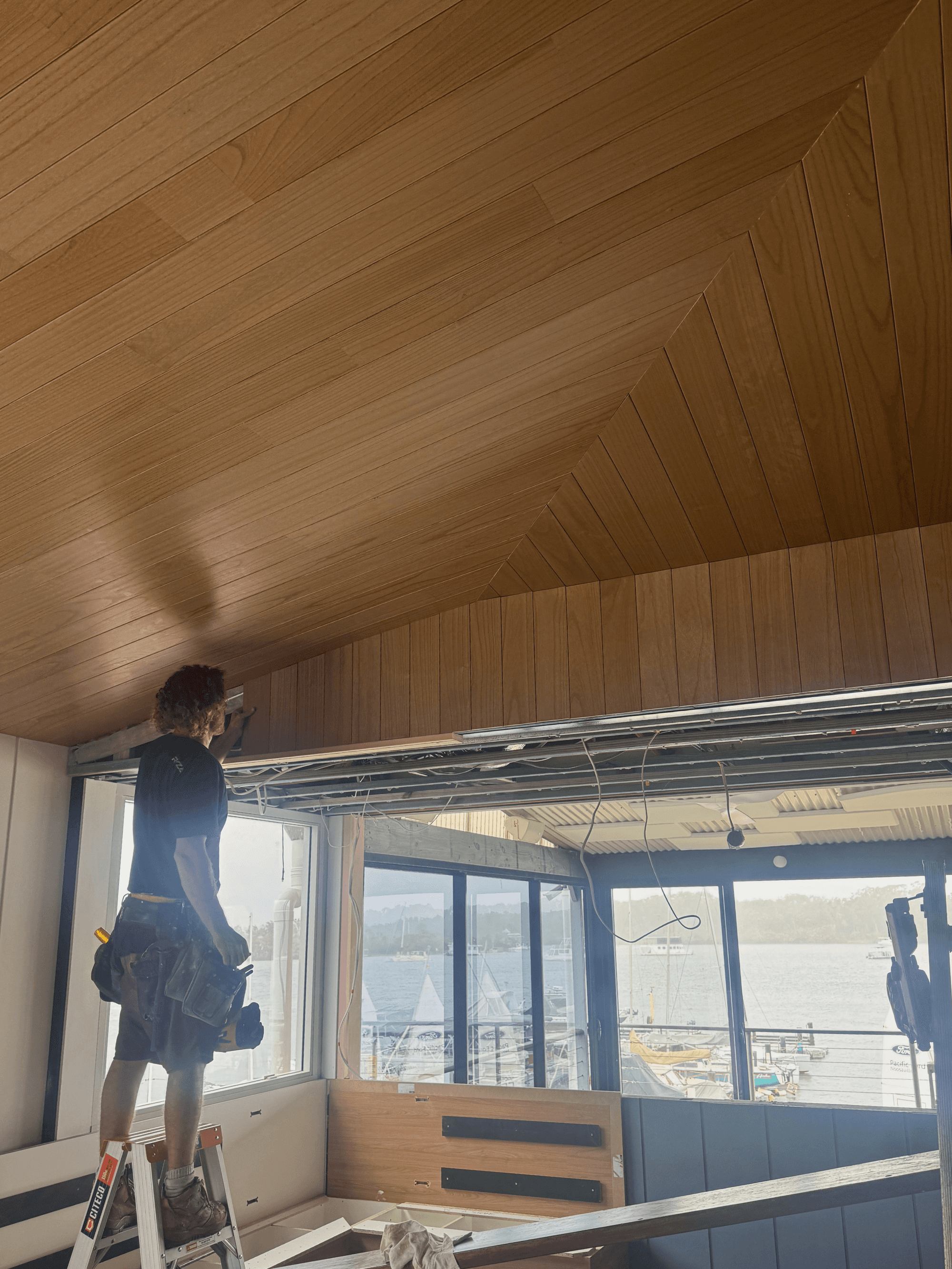Commercial interior featuring custom timber ceiling finishes and architectural detailing.