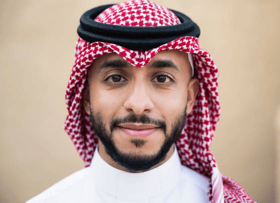 man smiling and using MacBook