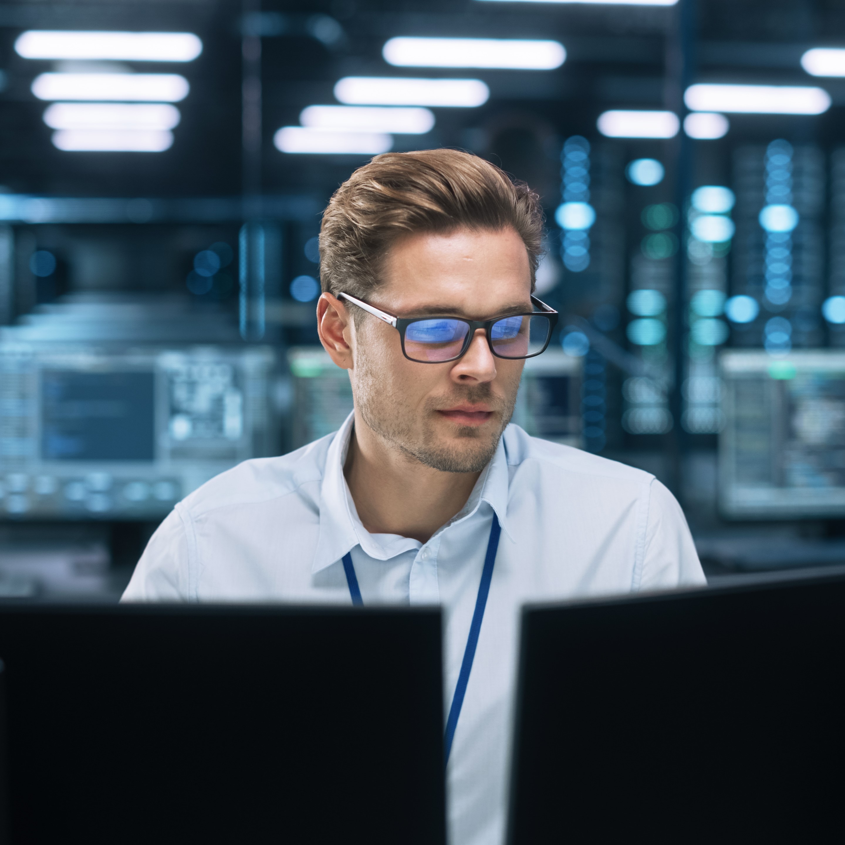 Telecommunications expert focused on network security monitoring at a data center, representing the critical tech talent in the telco industry for maintaining robust connectivity.