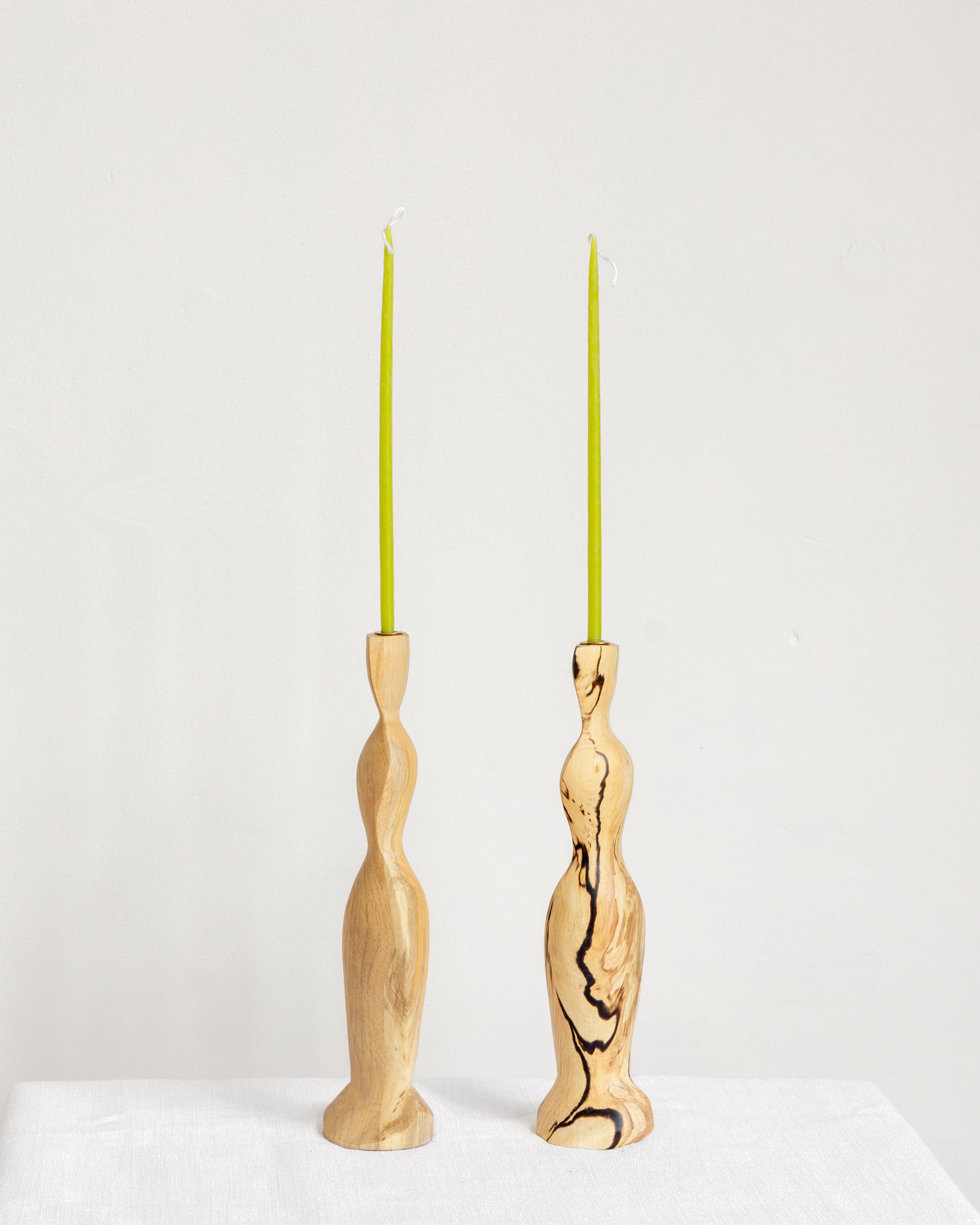 Figura Candlestick holders in Spalted on white background with green candles