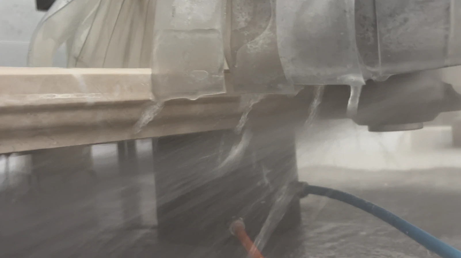 Close-up of a CNC router wheel cutting an edge profile into stone