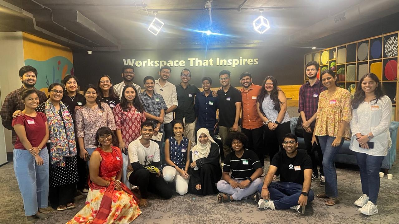 A large group of design students poses together in a colorful room, some seated and others standing, smiling at the camera in design day workshop organised by kaphal studio