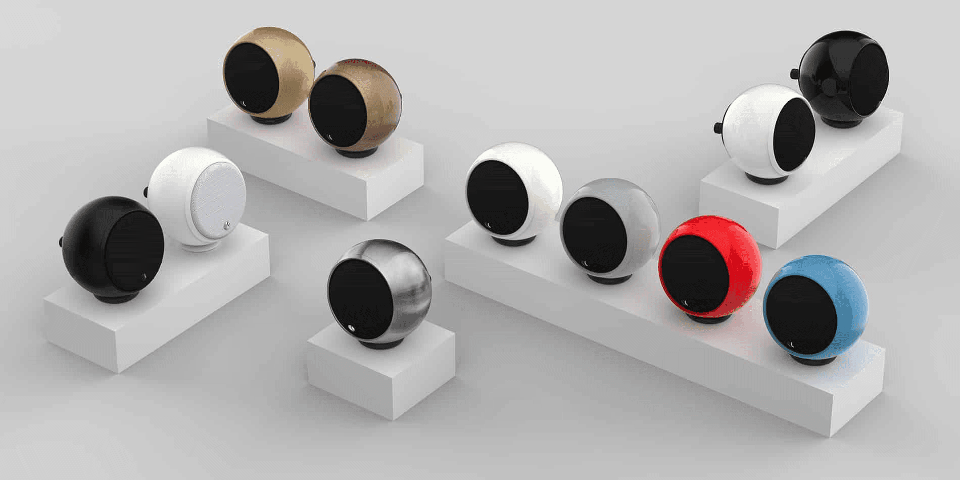 Spherical speakers in assorted colors on display pedestals.