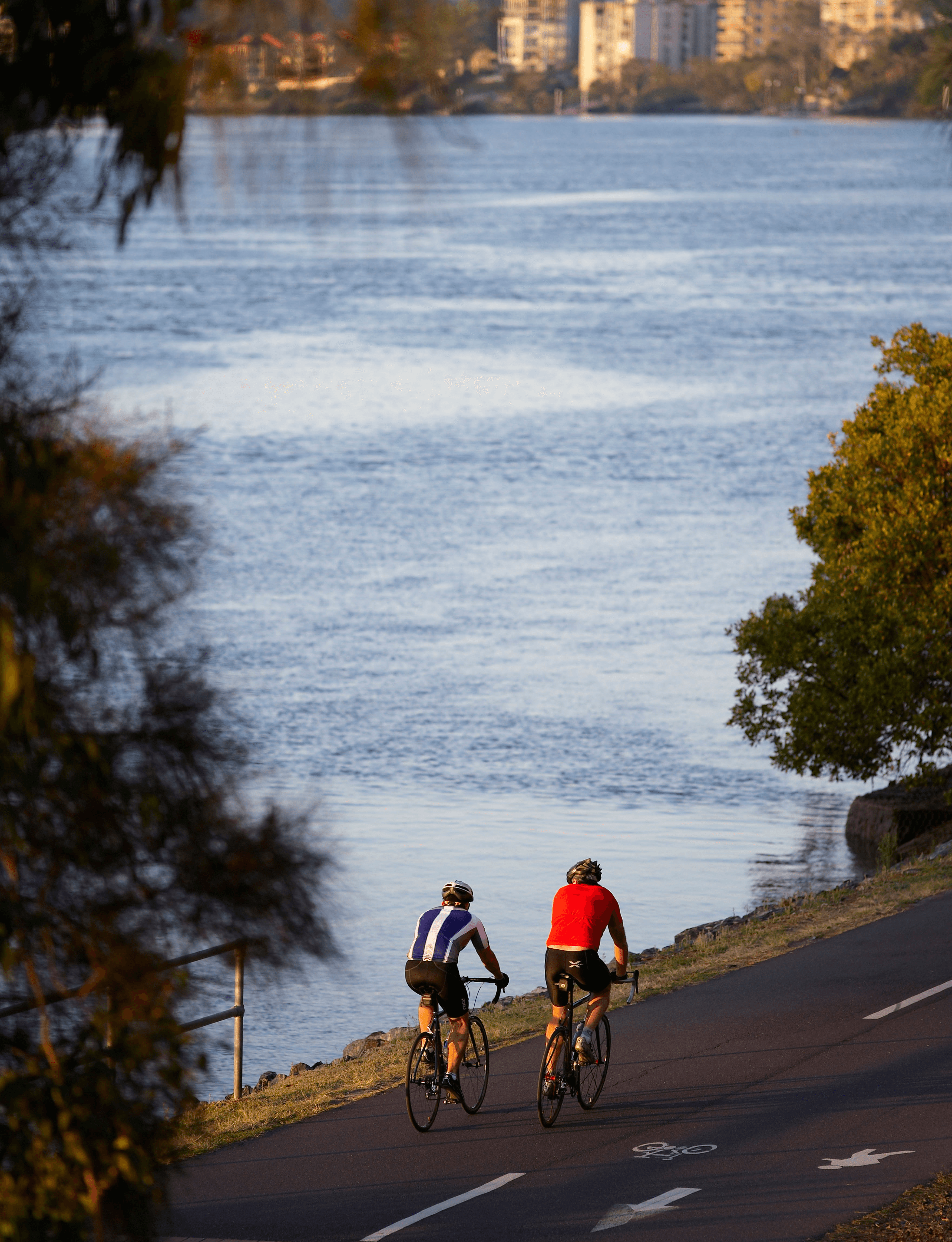 Woman standing outside in the sun, reflecting one of our colleges.