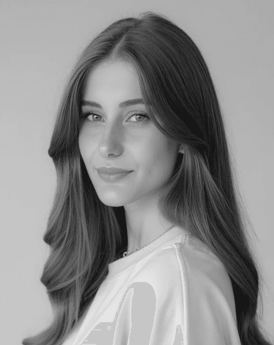 A thoughtful young person with dark hair gazes to the side, captured in soft black and white lighting.